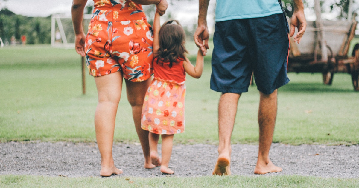 man and woman holding their daughter