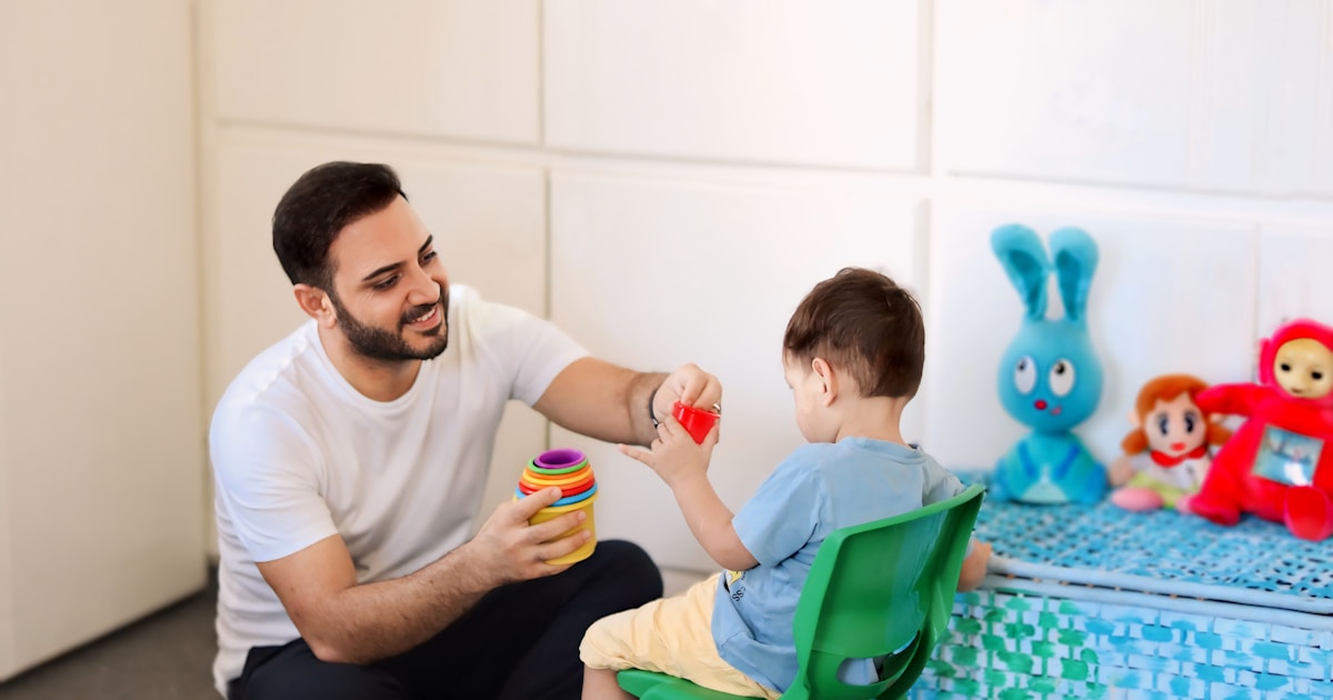 A man is playing with a child in a room